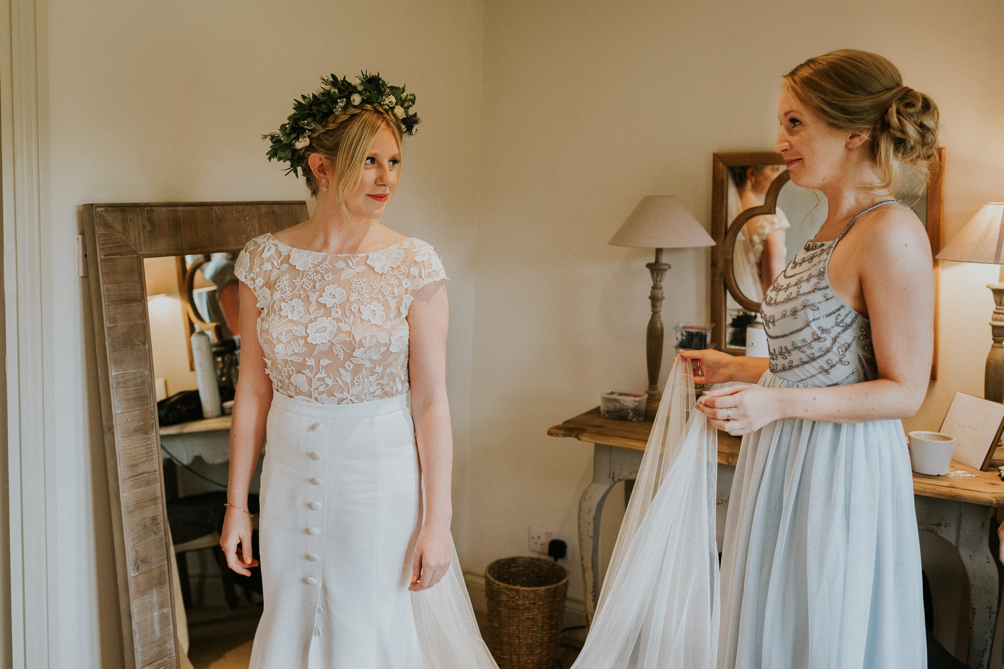 bride and her bridesmaid getting ready