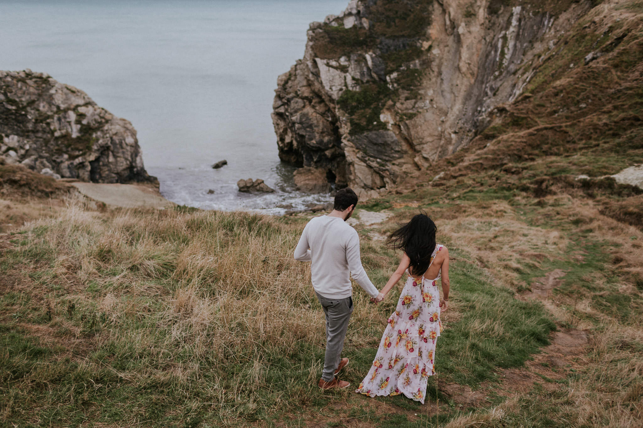 Couple walking along the coast in Lulworth Cove